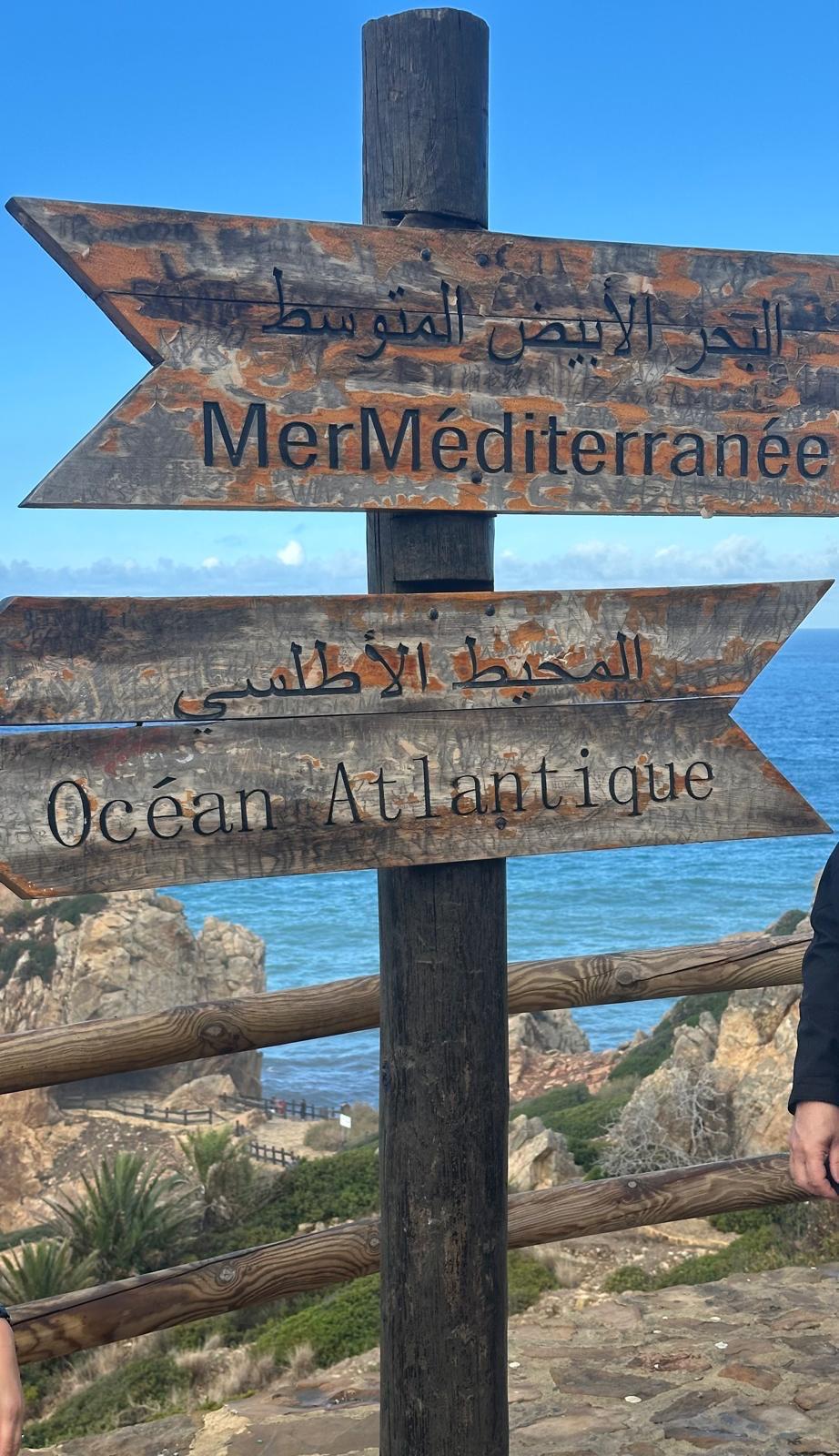 Wooden signpost pointing to the Mediterranean Sea and the Atlantic Ocean